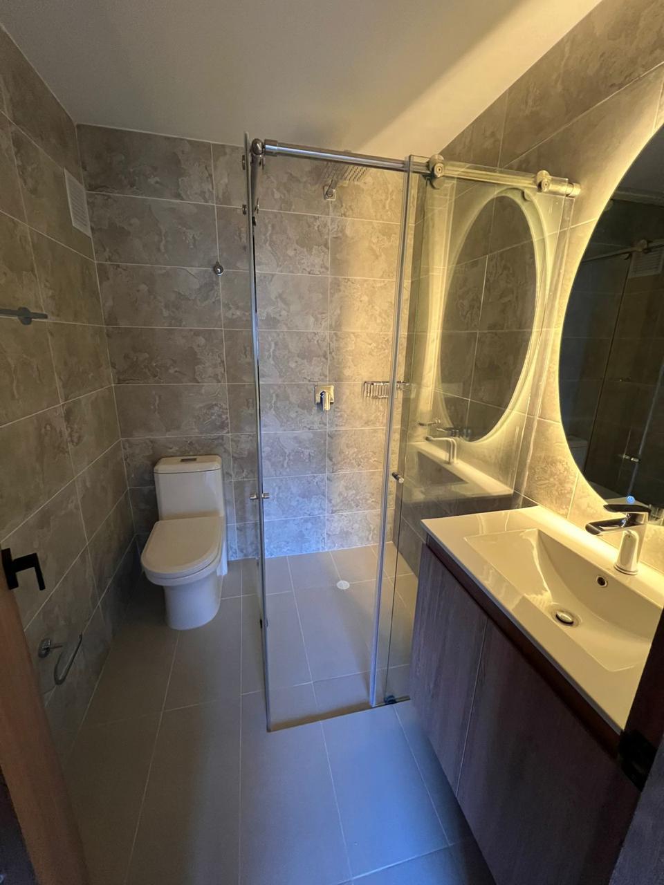 Baño remodelado con ducha en vidrio y enchape travertino — Vertika Remodelaciones Bogotá